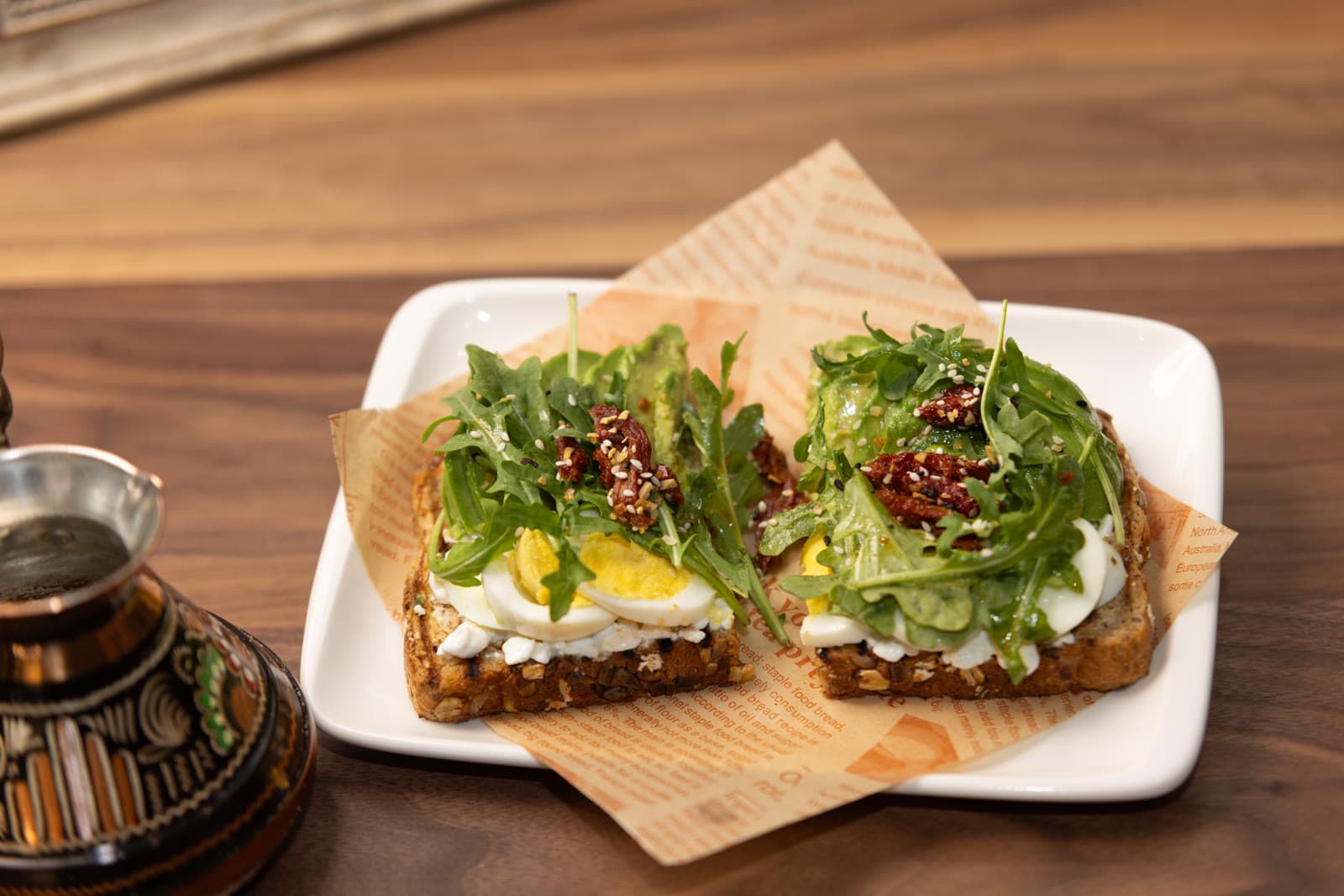 Close-up of eggs avocado toast with arugula and sesame