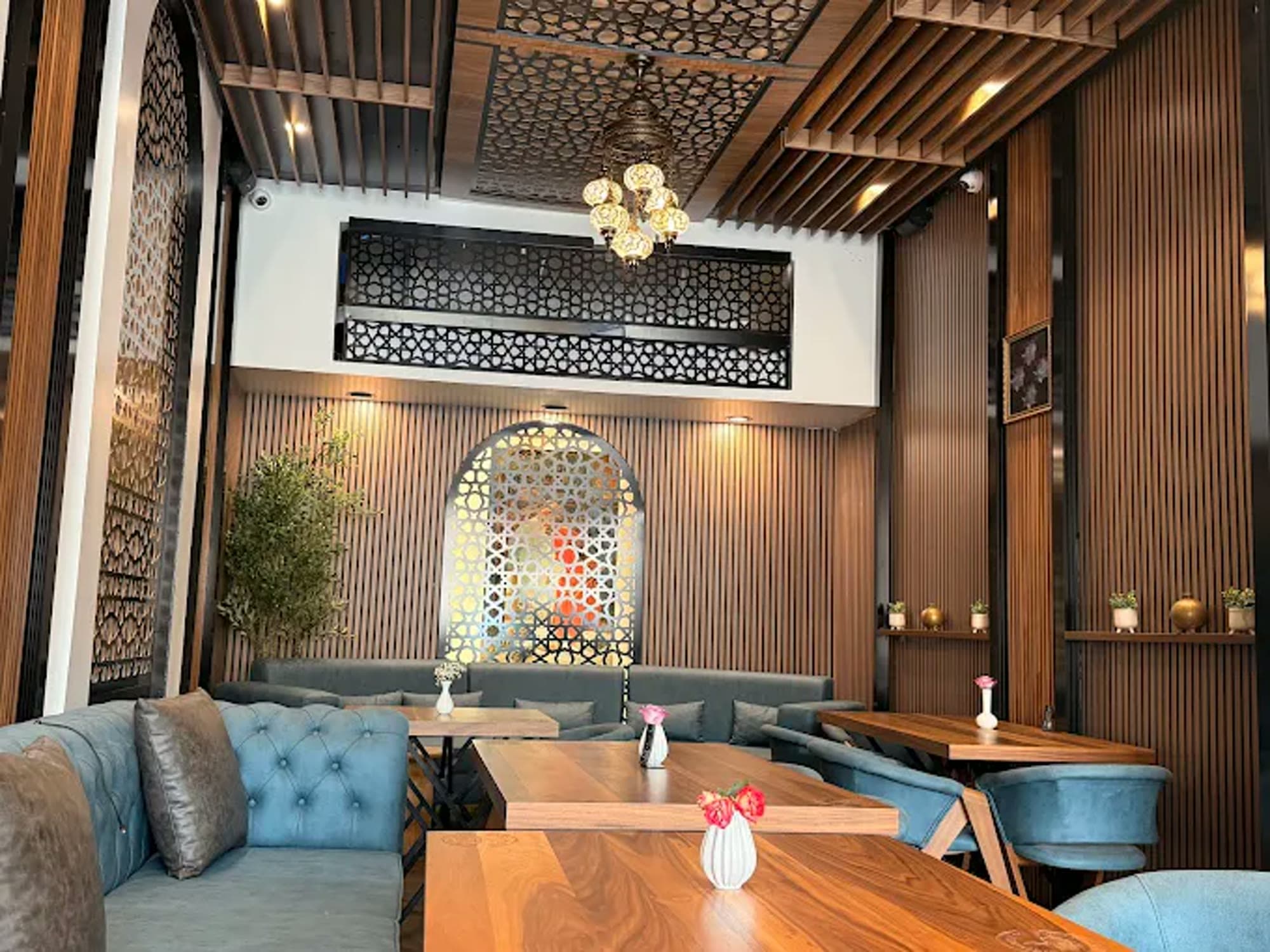 Teal velvet banquette seating beneath the geometric ceiling medallion